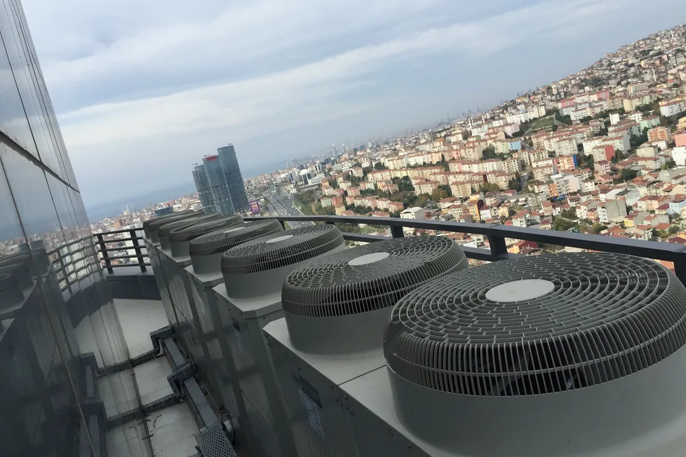 Kuriş Kule terasında şehir manzarası önünde sıralı VRF dış ünite fanları